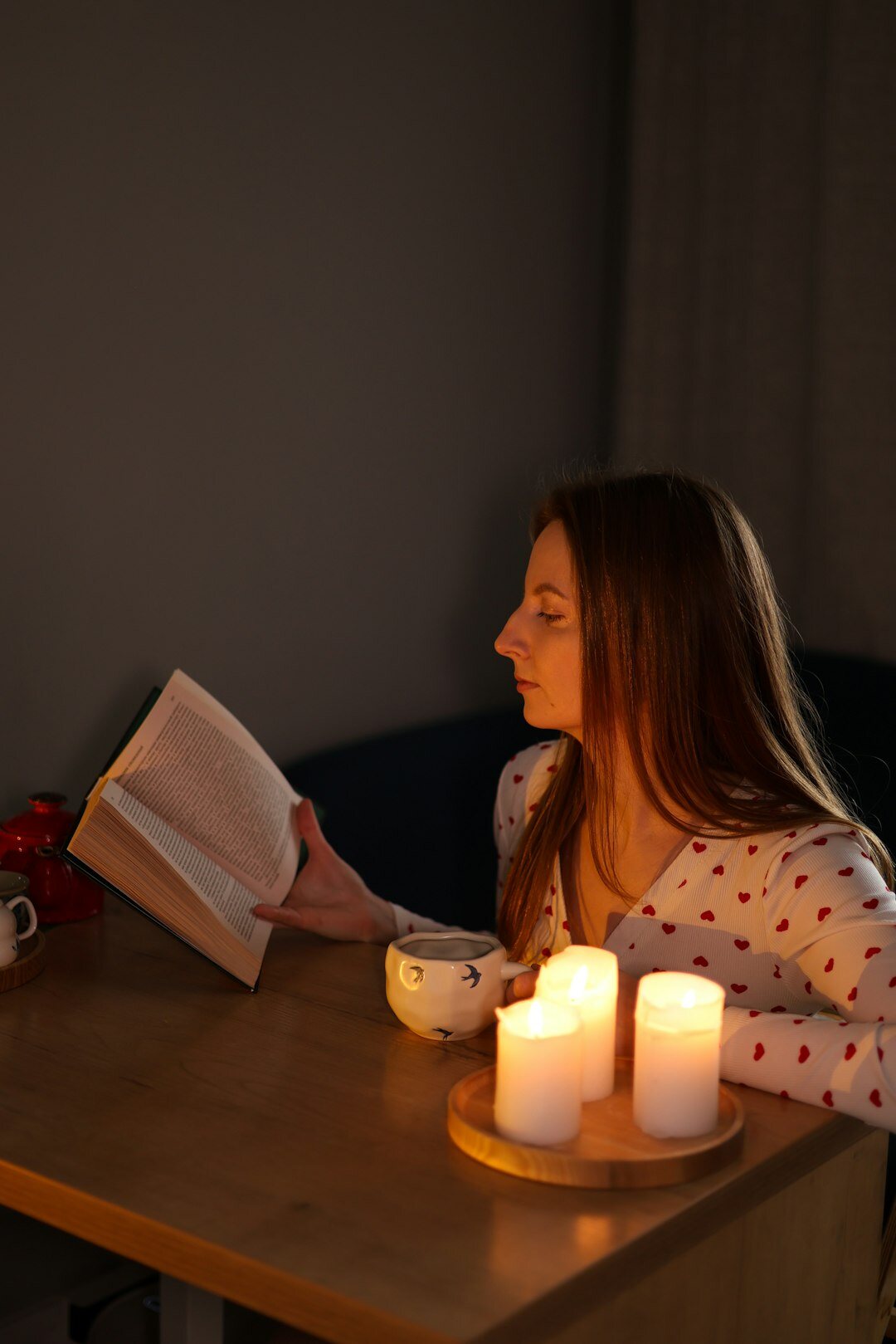 Danish woman relaxing at home surrounded by candles in a cozy hygge setting
